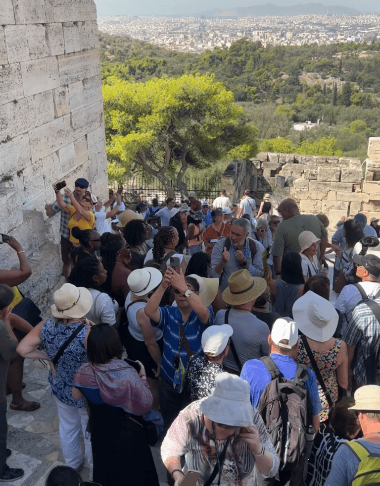 Multitudes en las escaleras de la Acrópolis en Atenas, Grecia, mostrando el impacto del turismo masivo.