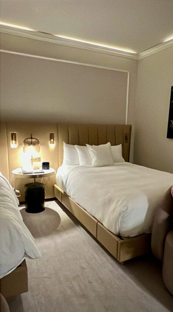 Guest room at Hôtel Vogue Montréal Downtown with channel-tufted headboard and warm cove lighting, featured in The Queen of Trips guide on where to stay in Montréal 2026.