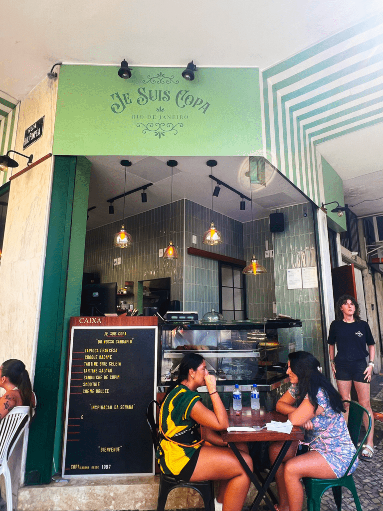 Where to stay in Rio: Je Suis Copa, a French-Brazilian café in the Copacabana neighborhood of Rio de Janeiro with green-and-white striped exterior, outdoor seating, and a tapioca and crepe menu