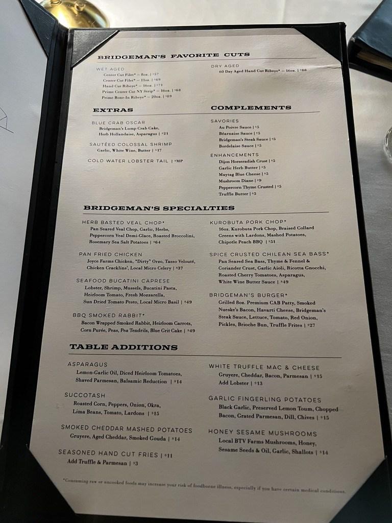 Dinner menu at Bridgeman's Chophouse showing hand-cut wet- and dry-aged steaks, specialties, and sides