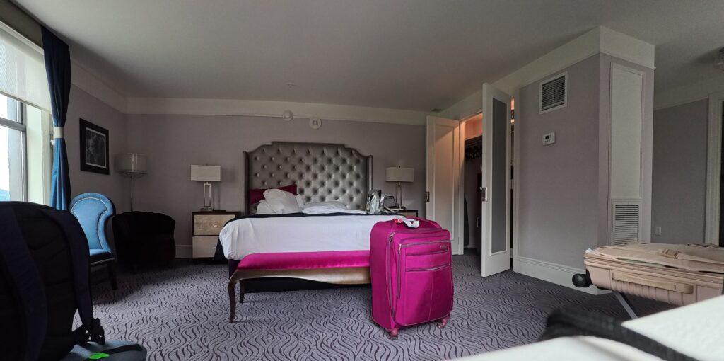 Premier King guest room at the Read House hotel in Chattanooga with a tufted headboard and blue velvet chairs