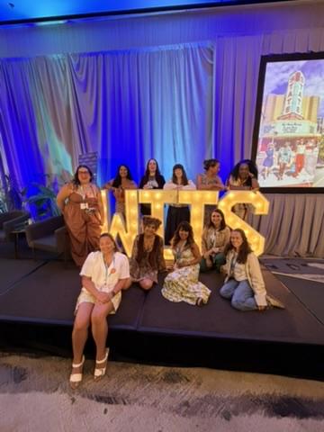 Group of women travel creators posing with lighted WITS letters at the Women in Travel Summit 2026 in Chattanooga